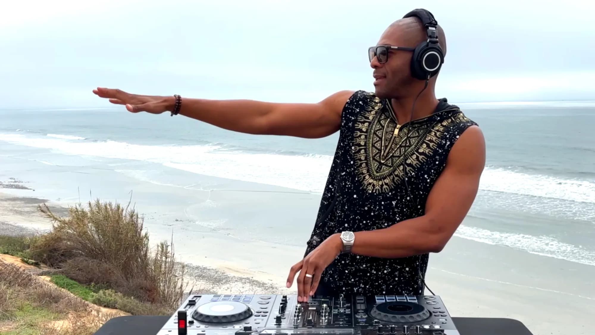 DJ NEXYS performing an open-air coastal set